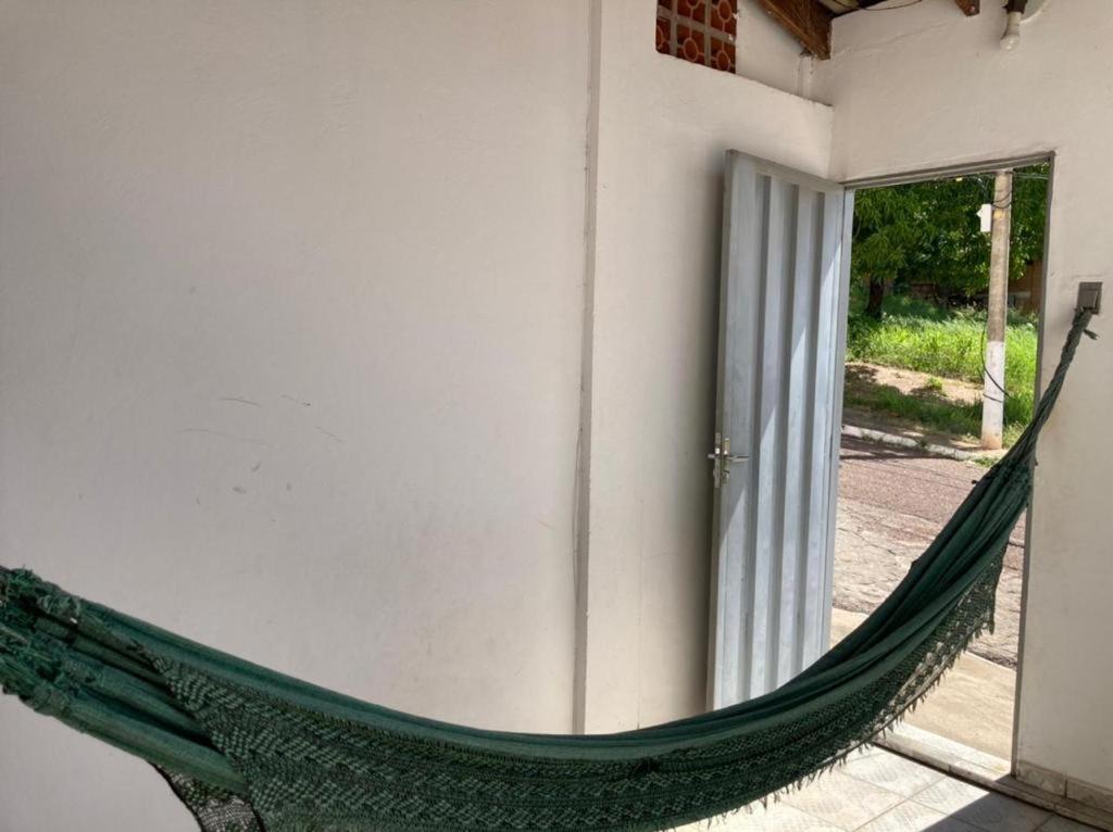 a green hammock leaning against a building at Aluguel de loft mobiliado em Cuiabá in Cuiabá