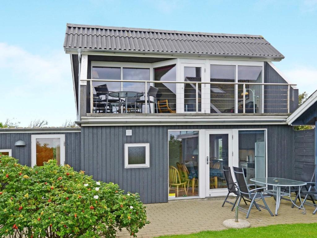 a gray house with a table and chairs at 6 person holiday home in Hemmet in Falen