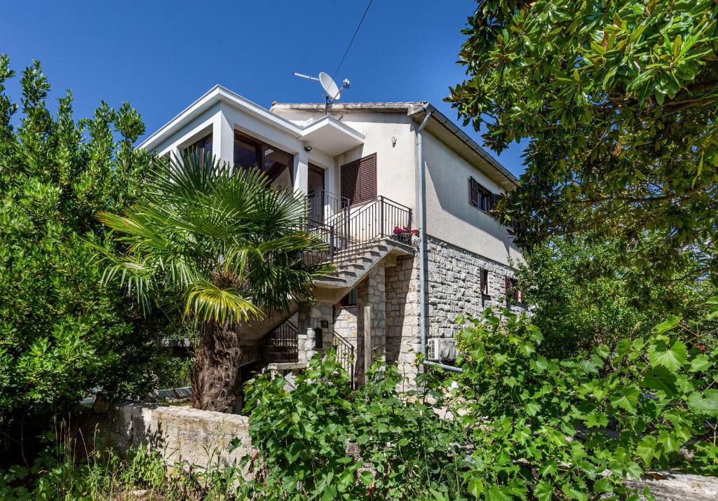 a house with a staircase and a palm tree at Apartment Magnolia in Šilo