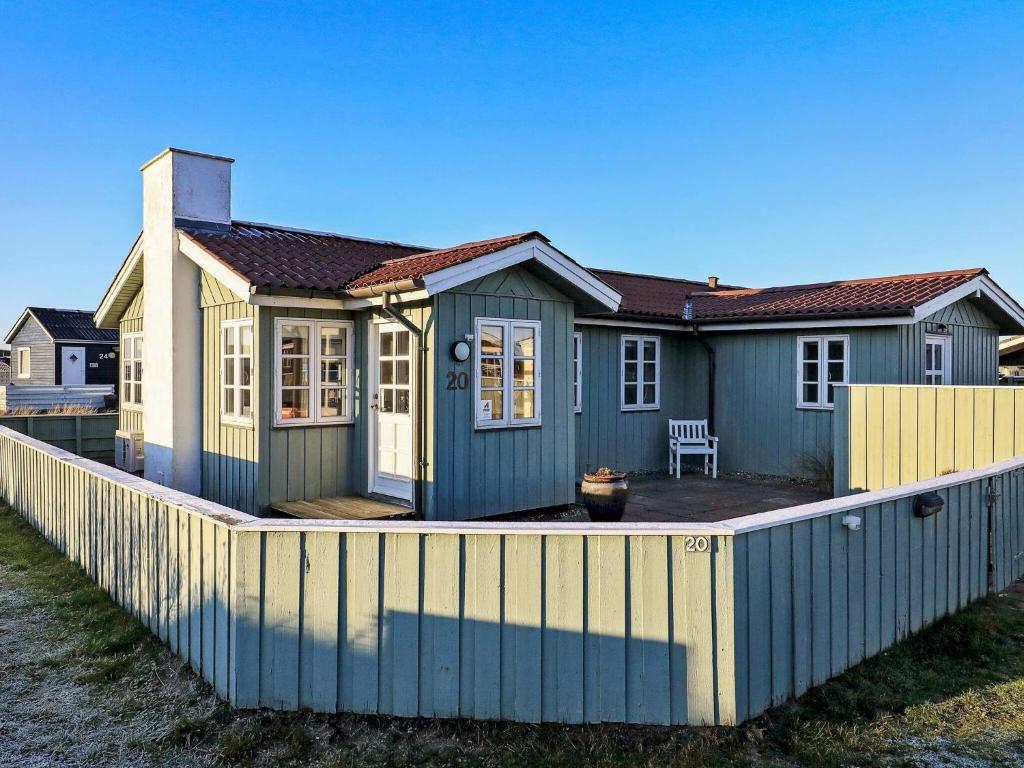 ein Haus mit einem Zaun davor in der Unterkunft 6 person holiday home in L kken in Løkken