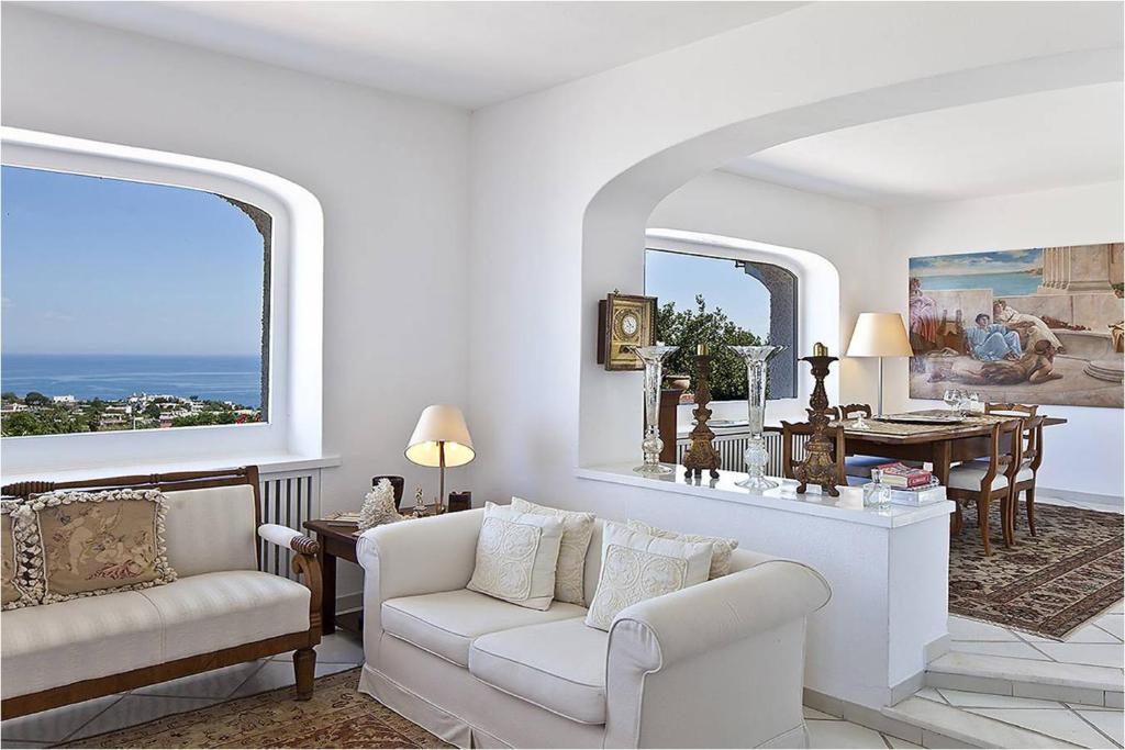ein Wohnzimmer mit einem Sofa und einem Tisch in der Unterkunft Luxury Relais Villa Magdalena in Ischia