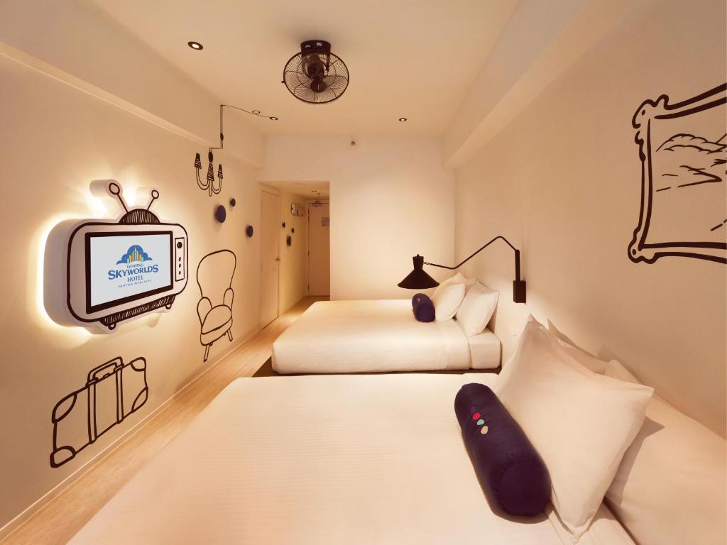 a bedroom with two beds and a tv at Resorts World Genting - Genting SkyWorlds Hotel in Genting Highlands