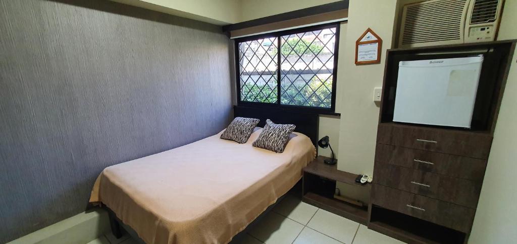 Habitación pequeña con cama y ventana en Apartamento habitación pequeña para ejecutivos o parejas, en Manta