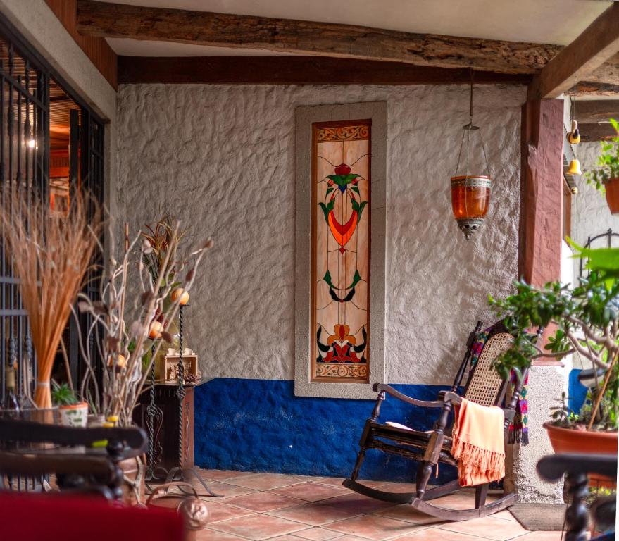 un patio con una pintura en una pared con sillas en La Casa de Mamá Coyita, en Cartago