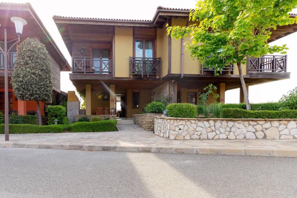 a house with a stone retaining wall in front of it at Villa Aurora, komplex Sozopolis in Sozopol