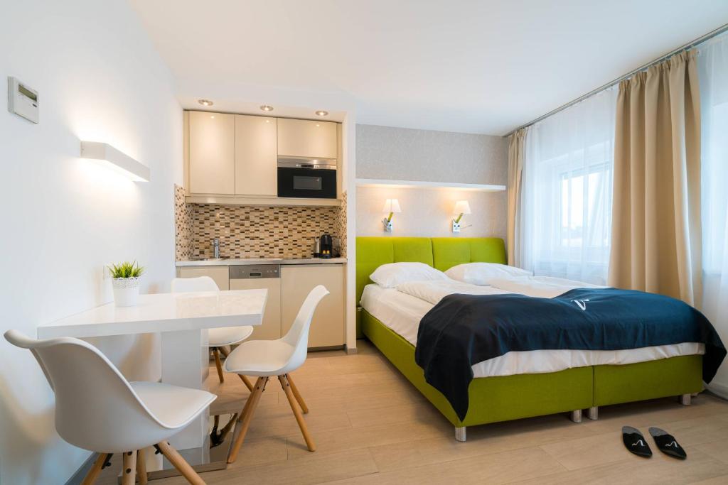 une chambre d'hôtel avec un lit, une table et des chaises dans l'établissement Vienna Residence, Rochusmarkt - Wien Mitte, à Vienne