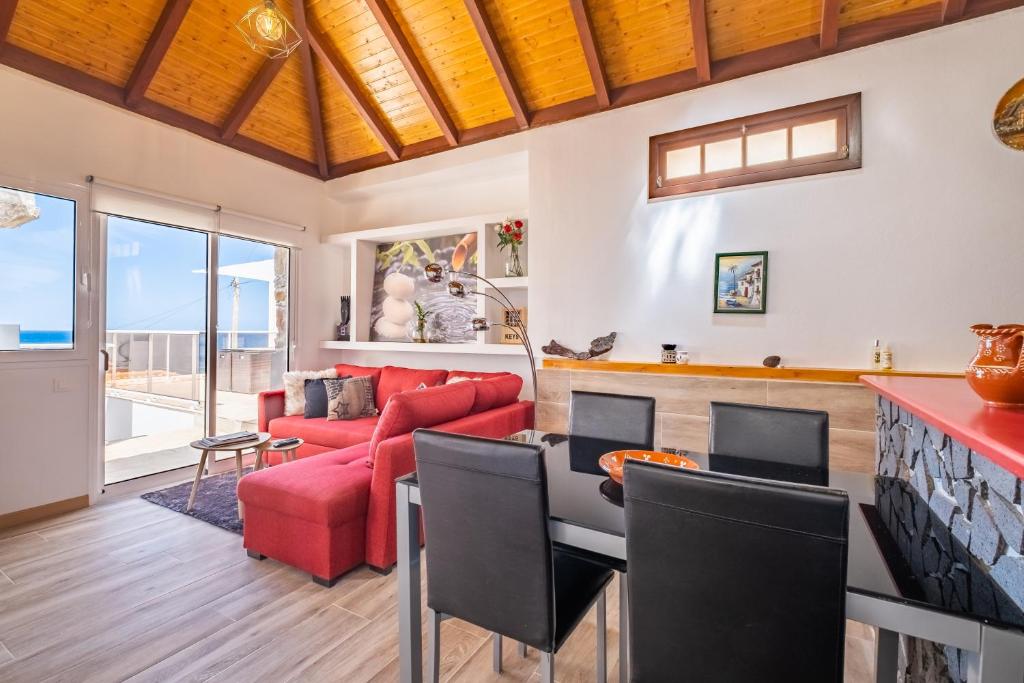uma sala de estar com um sofá vermelho e uma mesa em Recanto Jardim Do Mar em Jardim do Mar