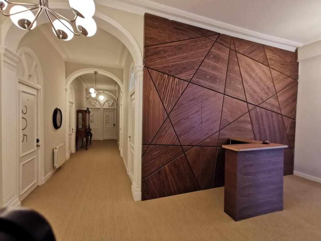 un couloir avec un grand mur en bois dans un bâtiment dans l'établissement Plaza Pombo B&B - Hostal, à Santander