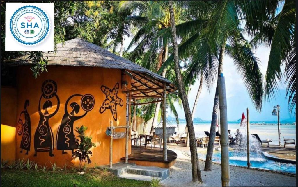 un edificio con graffiti junto a la playa en The Mud - Eco Hotel en Ban Bang Po