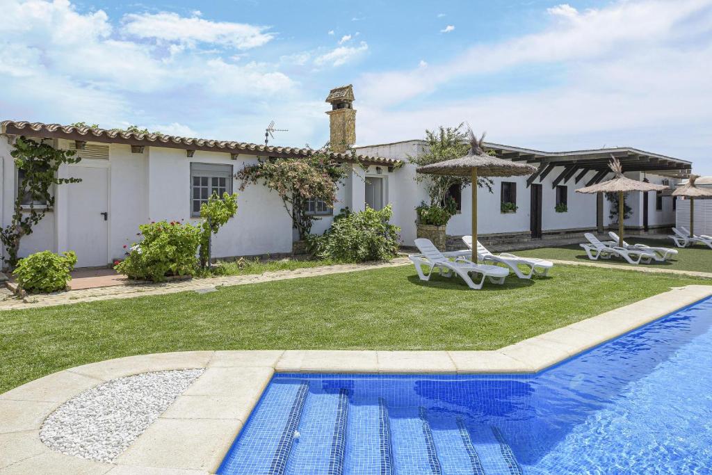 eine Villa mit einem Pool und einem Haus in der Unterkunft Finca Abril 2 Piscina Compartida in Roche