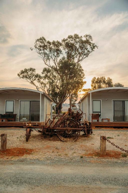an old tractor sitting in front of a building at Vineyard Views at Shiraz Republic in Cornella