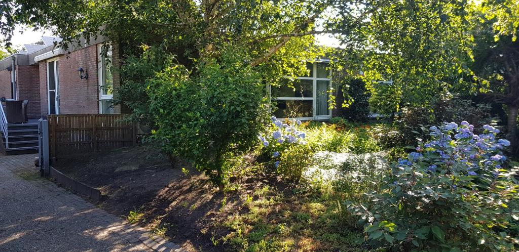 a garden in front of a house with flowers at Vakantiehuis Salamander Maasmechelen in Maasmechelen