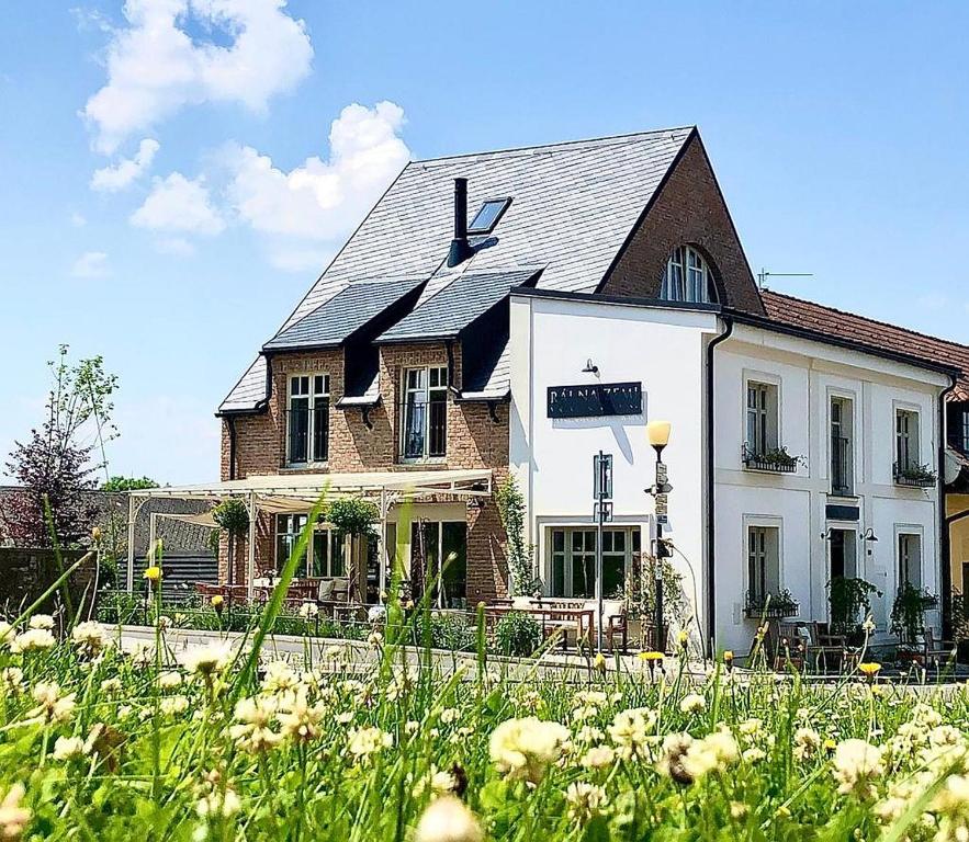 uma casa branca com um telhado preto em Ráj na zemi venkovský hotel a kavárna em Hukvaldy