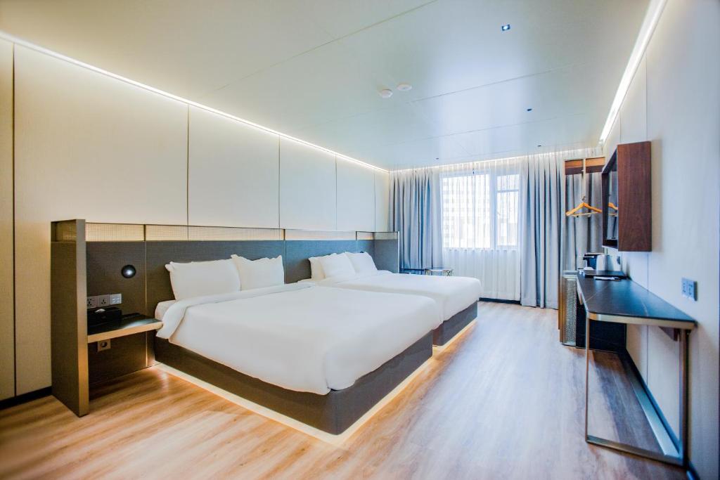 a large bedroom with a large bed and a desk at Amber Hotel Jeju in Jeju