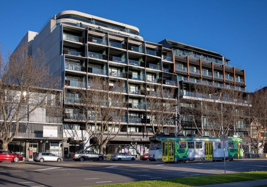 a bus is parked in front of a building at Modern, Quiet 1 Bed Apt on Fitzroy St, Opposite Albert Park in Melbourne