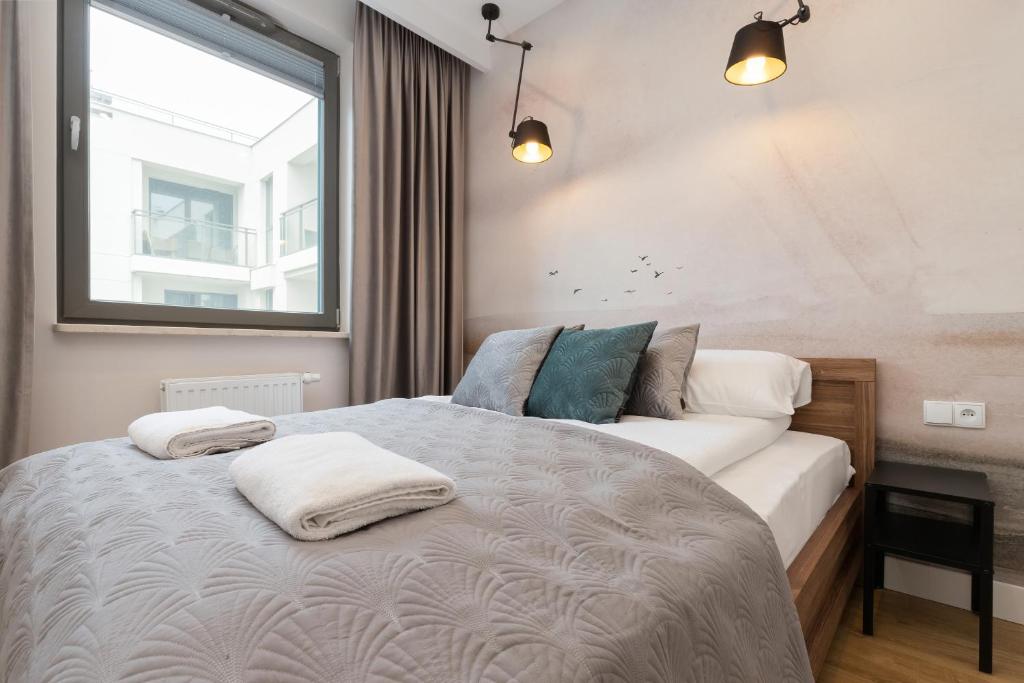 a bedroom with a bed with two pillows on it at Garden Gates Apartments by Renters in Gdańsk