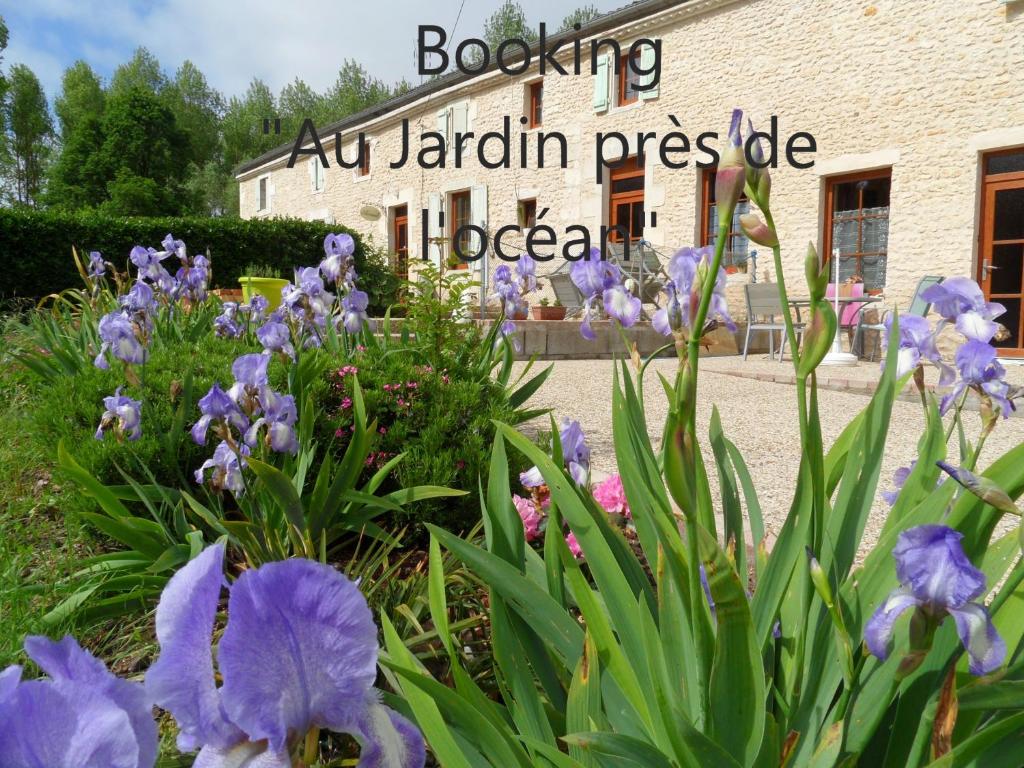 een tuin met paarse bloemen voor een gebouw bij Au Jardin près de l'ocean in Les Mathes