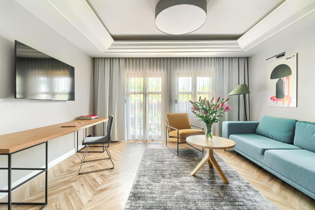 a living room with a blue couch and a table at City Apartments - Apartamenty Butikowe in Koszalin