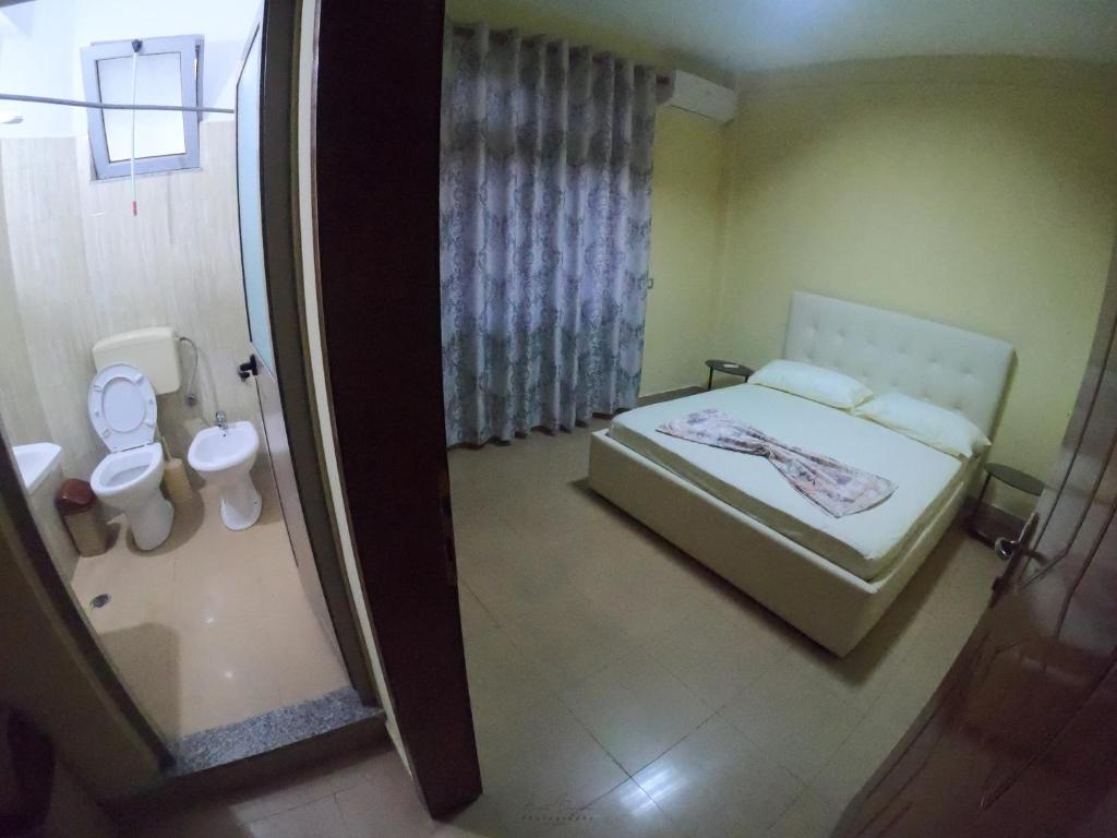 a small bedroom with a bed and a toilet at Central Hostel in Shkodër