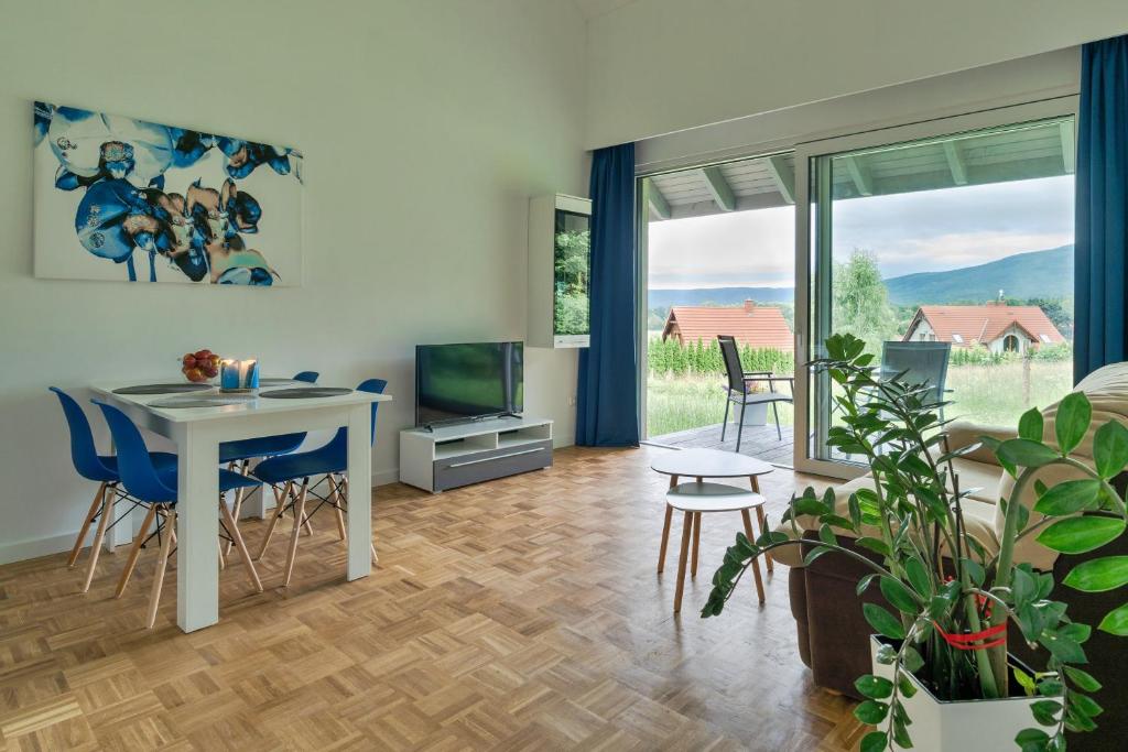 ein Wohnzimmer mit einem Tisch und Stühlen sowie einem TV in der Unterkunft Domek Ale Fajnie - taras z widokiem na góry in Karpacz