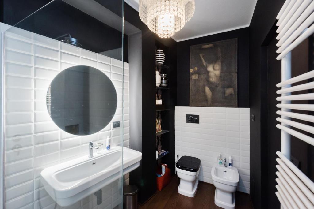 łazienka z umywalką, toaletą i lustrem w obiekcie Flats4rent Al Monte w Weronie