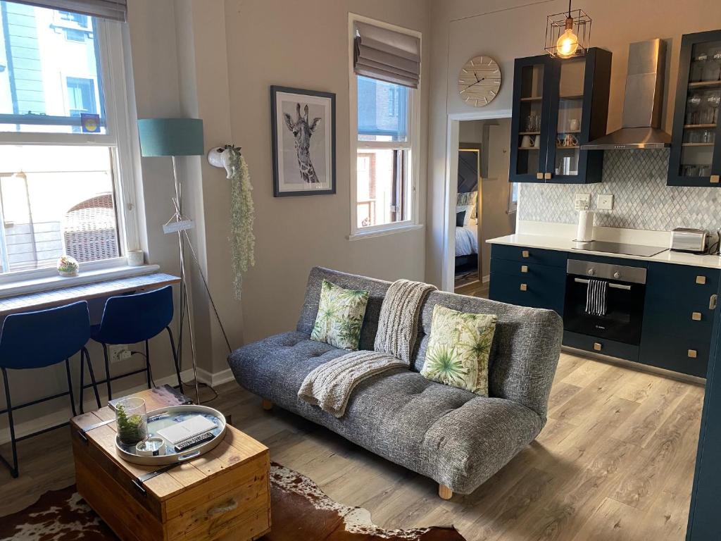 un salon avec un canapé et une cuisine dans l'établissement Just Off Long - Inner City Gem, au Cap