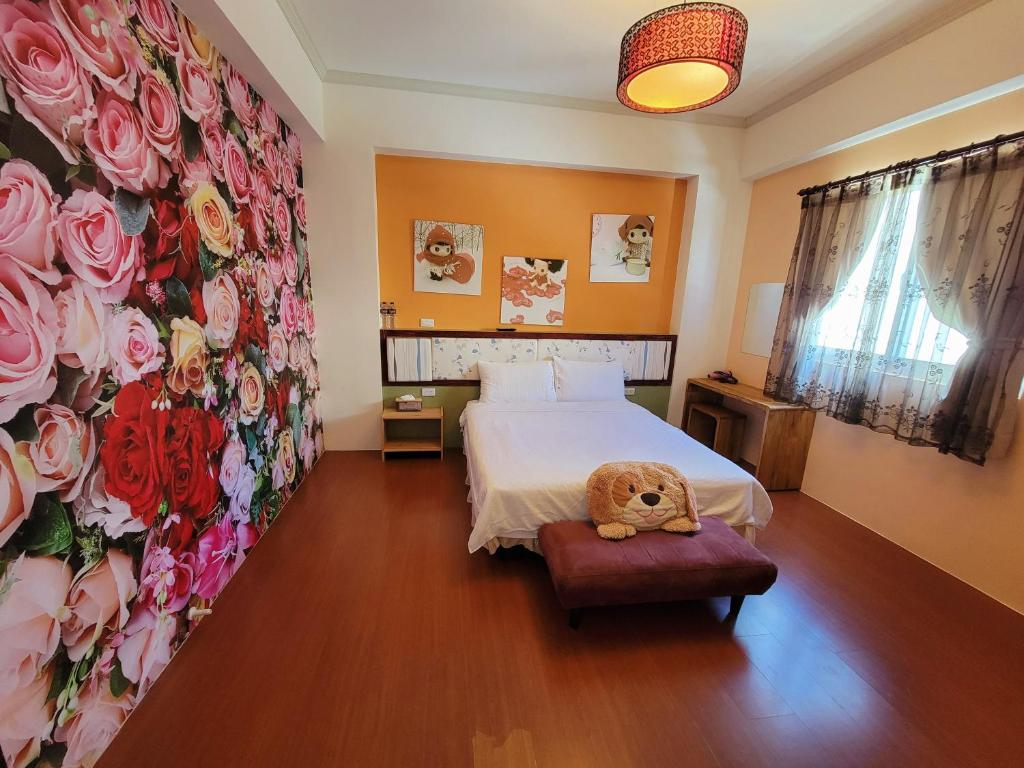 a bedroom with a bed with a teddy bear sitting on a stool at 草莓牛奶台東民宿可洽包棟 in Taitung City