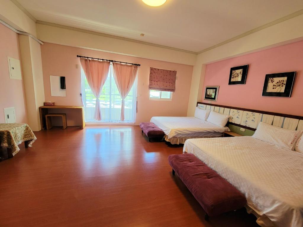 a large room with two beds and a window at 草莓牛奶台東民宿可洽包棟 in Taitung City
