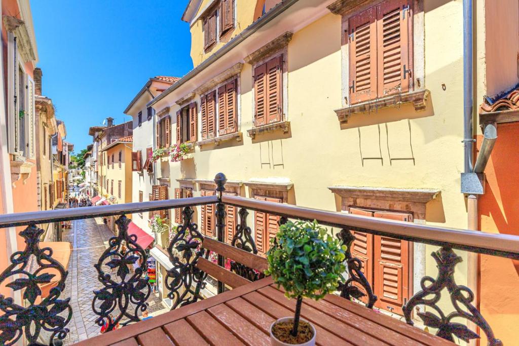 a wooden balcony with a potted plant on a street at Two bedroom Apartment La Mer in Poreč