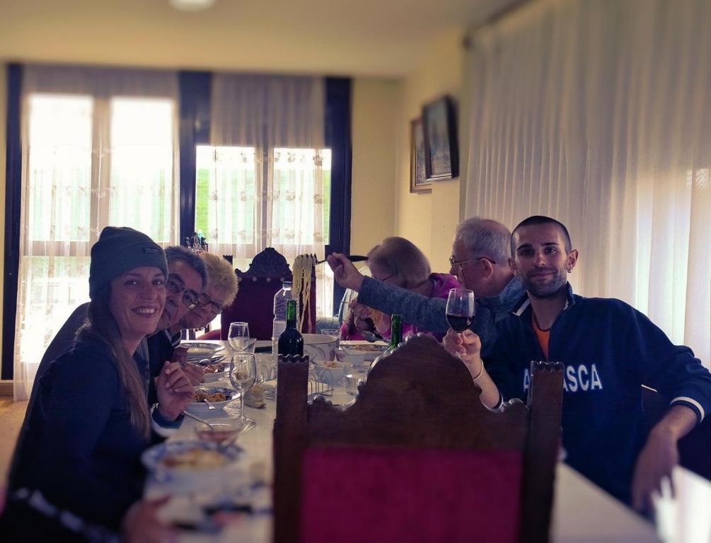 un grupo de personas sentadas en una mesa con copas de vino en Albergue Victoria, en Cirueña