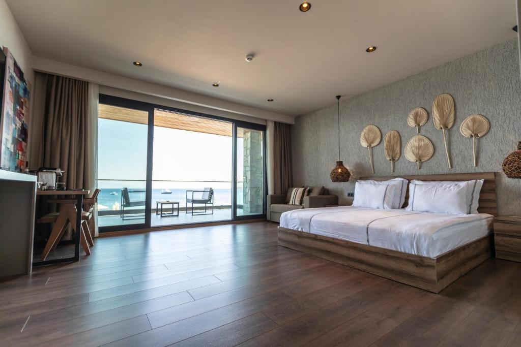 a bedroom with a bed with a view of the ocean at KHAI HOTEL BODRUM in Bodrum City