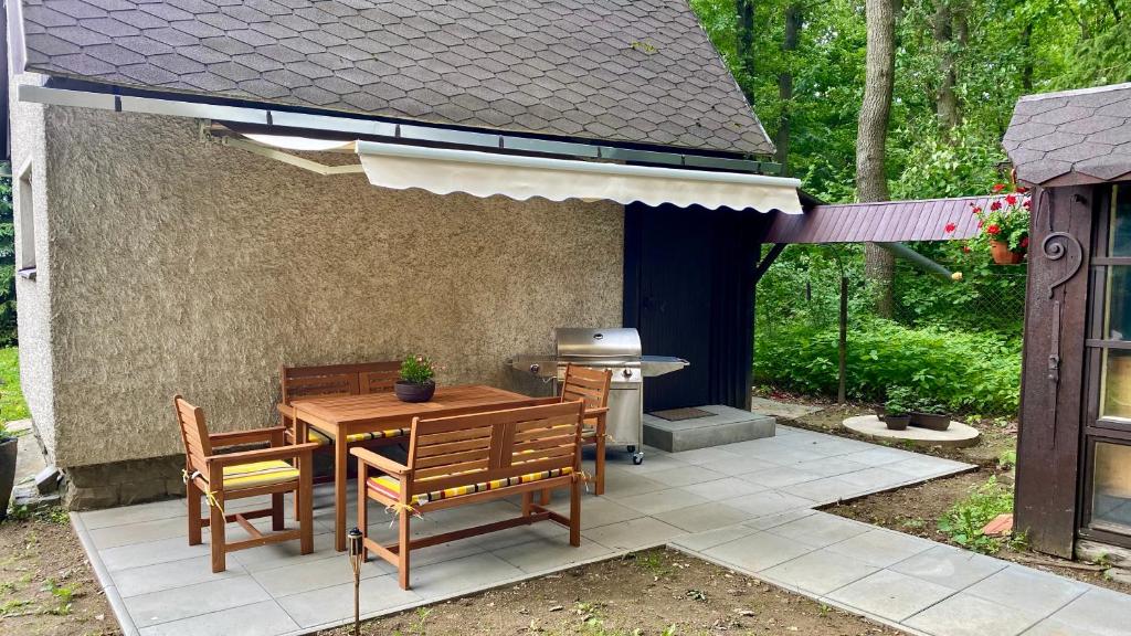 a patio with a table and chairs and a grill at Chata Ben in Chotěboř