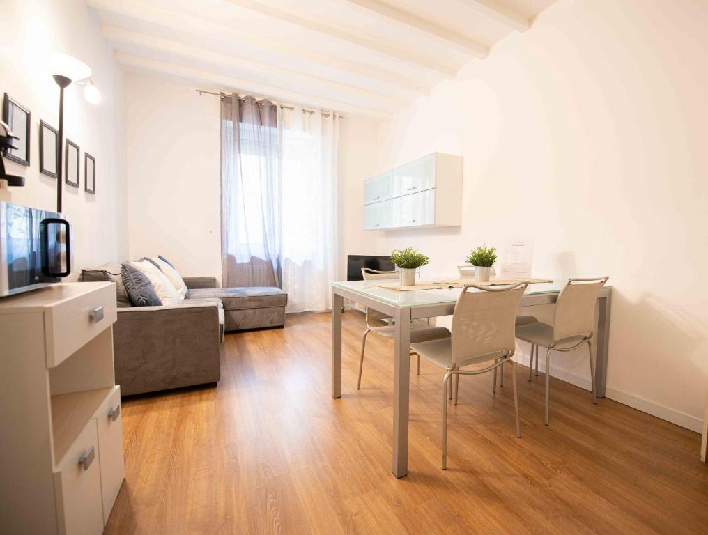 una cucina e un soggiorno con tavolo e sedie di Leoncino Apartment a Verona