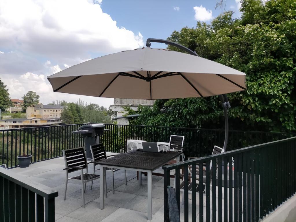 un tavolo e sedie con ombrellone su una terrazza di Casa rural en parque natural con entorno espectacular a Miraflores de la Sierra