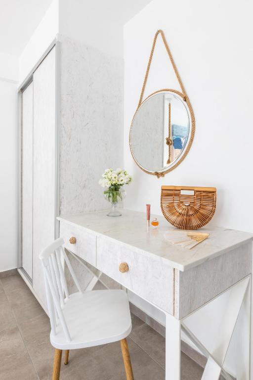 a white desk with a mirror and a chair at Blue Harbour Boutique in Ayia Napa