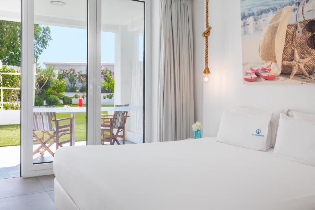 a bedroom with a white bed and a balcony at Blue Harbour Boutique in Ayia Napa