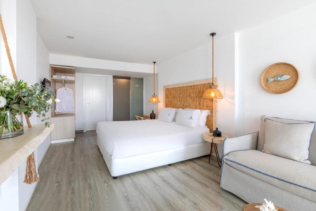 a bedroom with a white bed and a couch at Blue Harbour Boutique in Ayia Napa