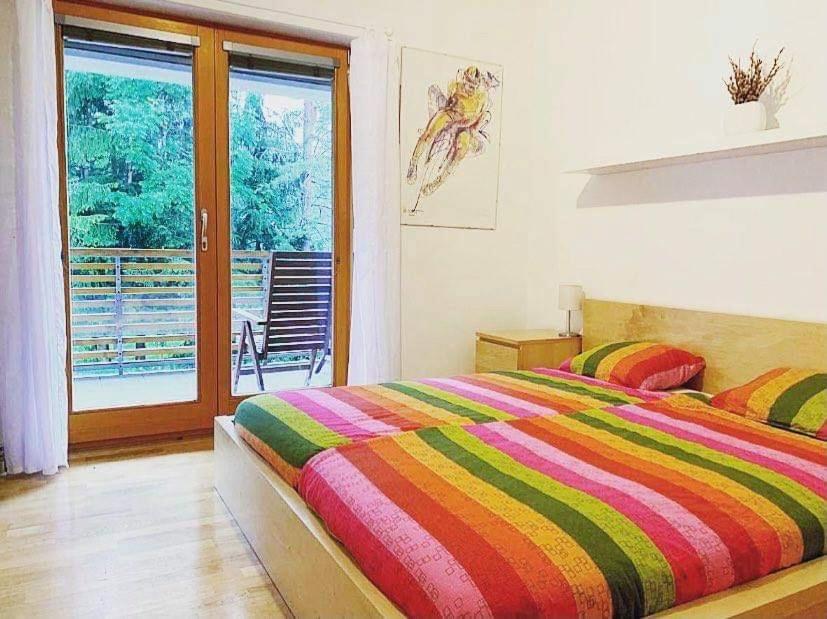 a bedroom with a bed with a colorful striped blanket at Apartment Lesnina in Kranjska Gora