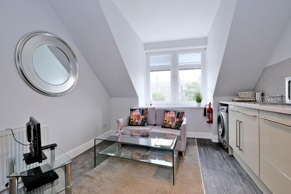 a living room with a couch and a glass table at Central Aberdeen Apartment in Aberdeen