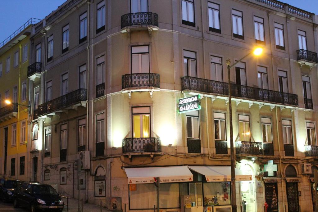 un grand bâtiment situé dans une rue de la ville la nuit dans l'établissement Estrela de Arganil - Luis Simões & Conceição, Lda, à Lisbonne
