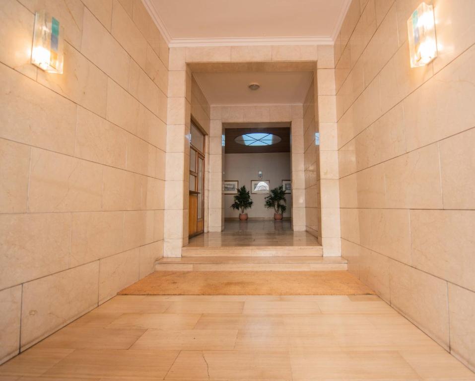 an empty hallway in a building with two plants at Leoncino Apartment in Verona