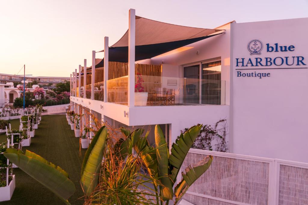 a building with a balcony with a sign that reads blue harbour boutique at Blue Harbour Boutique in Ayia Napa