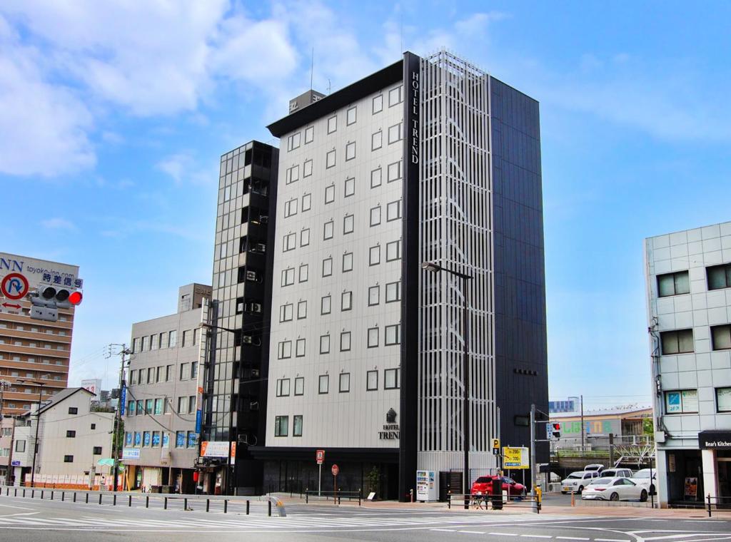 a tall white building with many windows on a city street at Hotel Trend Abeno Tennoji in Osaka