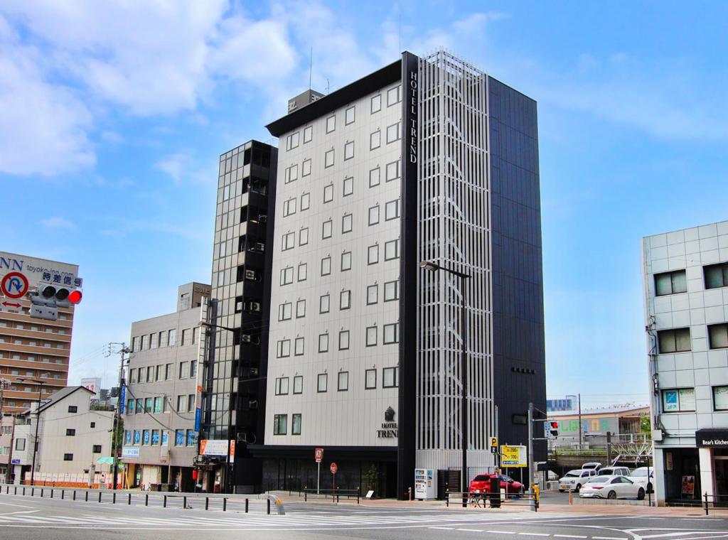ein hohes weißes Gebäude mit vielen Fenstern auf einer Stadtstraße in der Unterkunft Hotel Trend Abeno Tennoji in Osaka