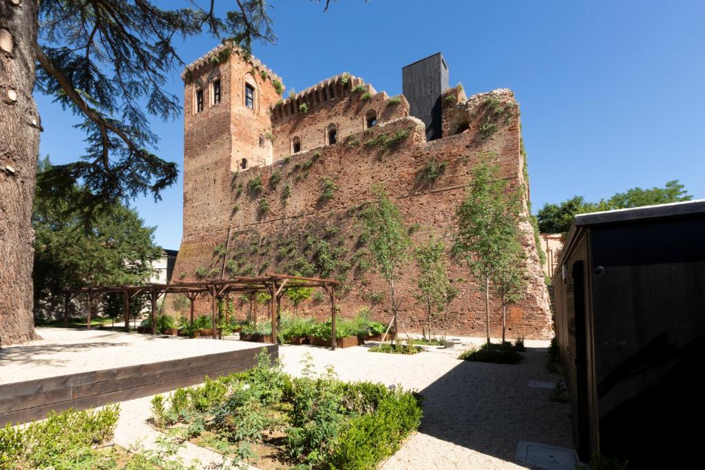 un gran edificio de ladrillo con hiedra. en Rocca di Arignano, en Arignano