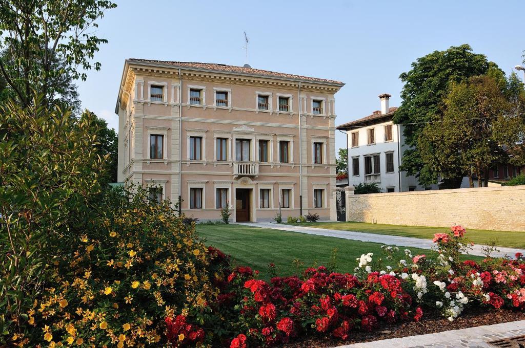 um grande edifício com flores em frente em Villa Maternini em Vazzola