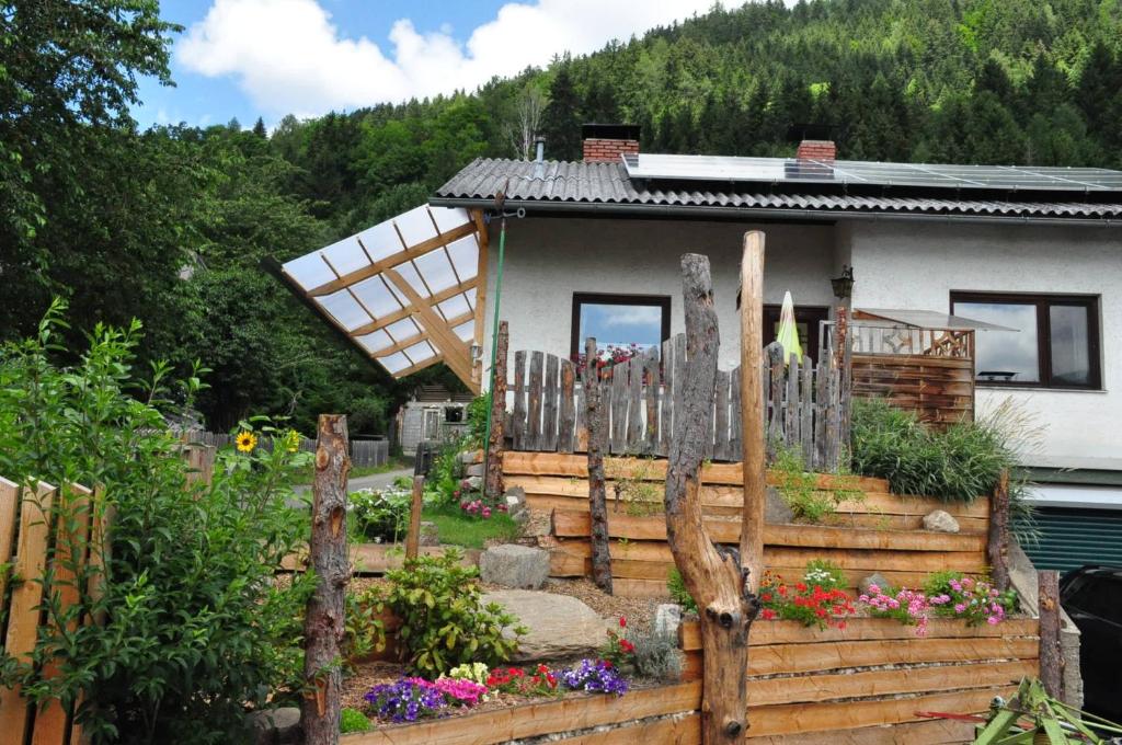 een huis met een houten hek en een tuin bij Ferienhaus Weiss in Lind bei Scheifling