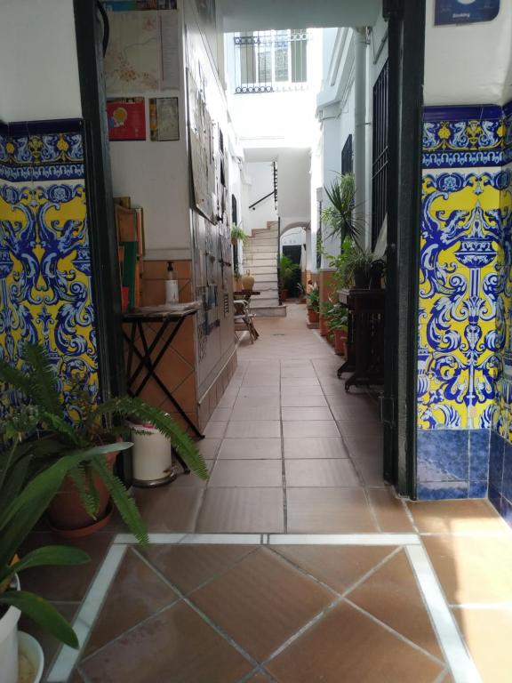 un pasillo vacío con azulejos y plantas azules y blancos en Apartamentos Fernando El Catolico, en Málaga