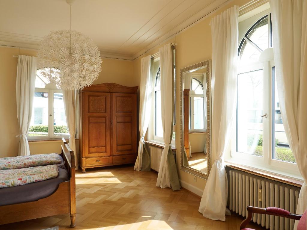 Schlafzimmer mit Fenstern, einem Bett und einem Spiegel in der Unterkunft Haus Bley in Wittlich