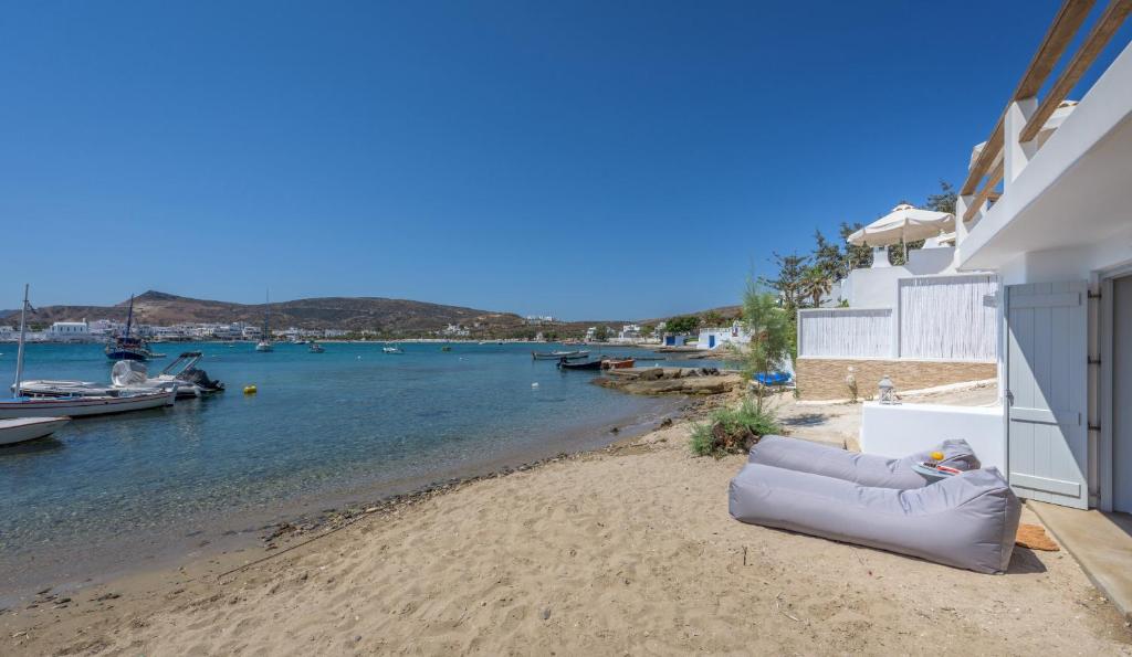 a couch on the beach next to a body of water at Michalakis Seaside Suites in Pollonia